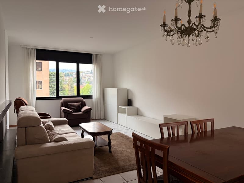 white walls, beige sofa, wooden coffee table, wooden dining table, wooden chairs, chandelier, white curtains, window, fireplace