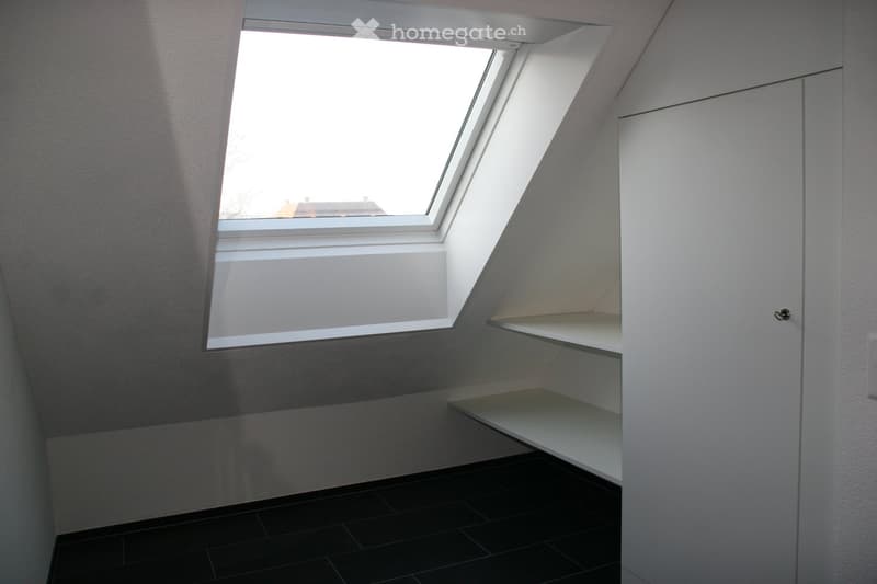 small room with a window, white walls, black tiles, white shelves, white door