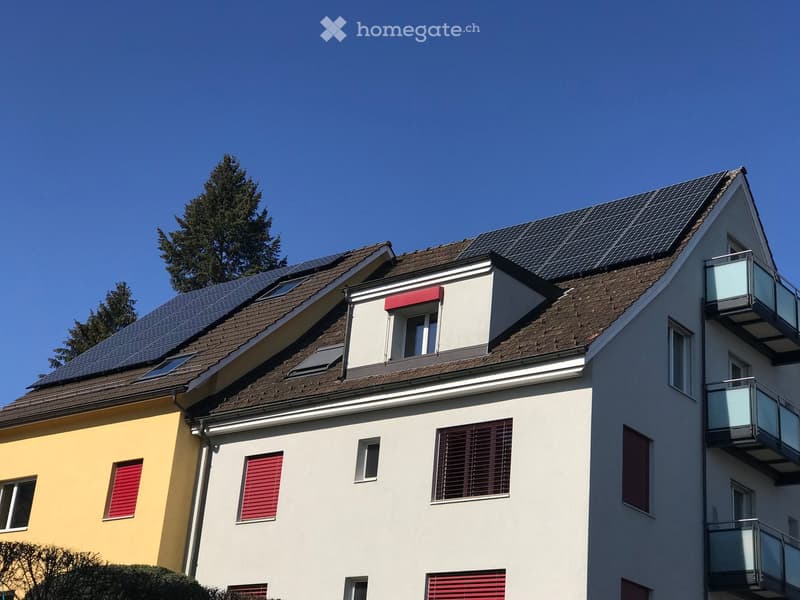 2 story house, white and yellow exterior, solar panels on roof, red shutters, balconies