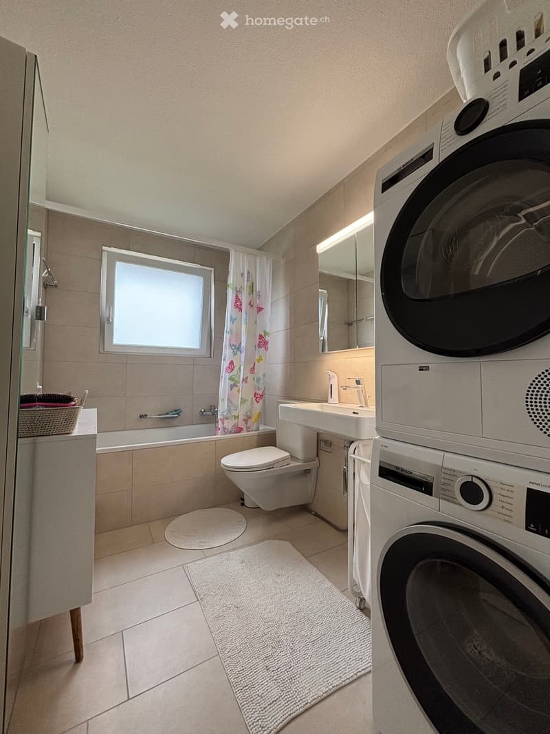 Bathroom with bathtub, toilet, sink, washing machine, and dishwasher.