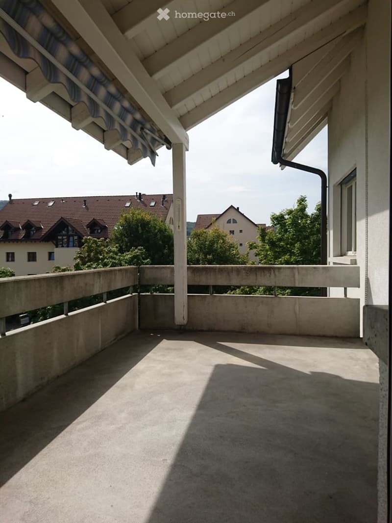 empty balcony with concrete floor and railings, covered by a roof