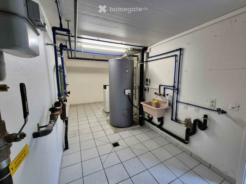 Utility room with tiled floor, water heater, sink, pipes, and electrical outlets