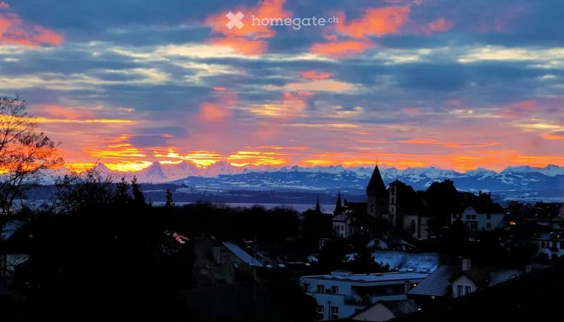 Sunset over a town with mountains in the background