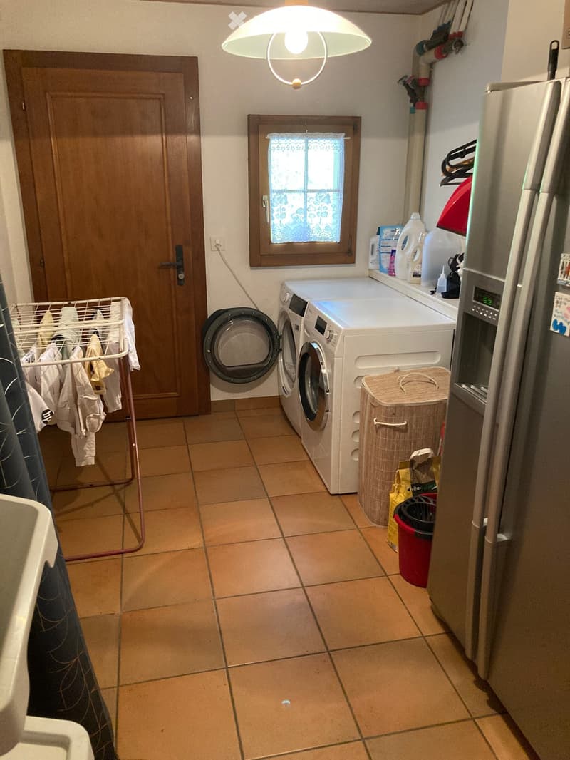Laundry room with washing machine, dryer, and refrigerator.