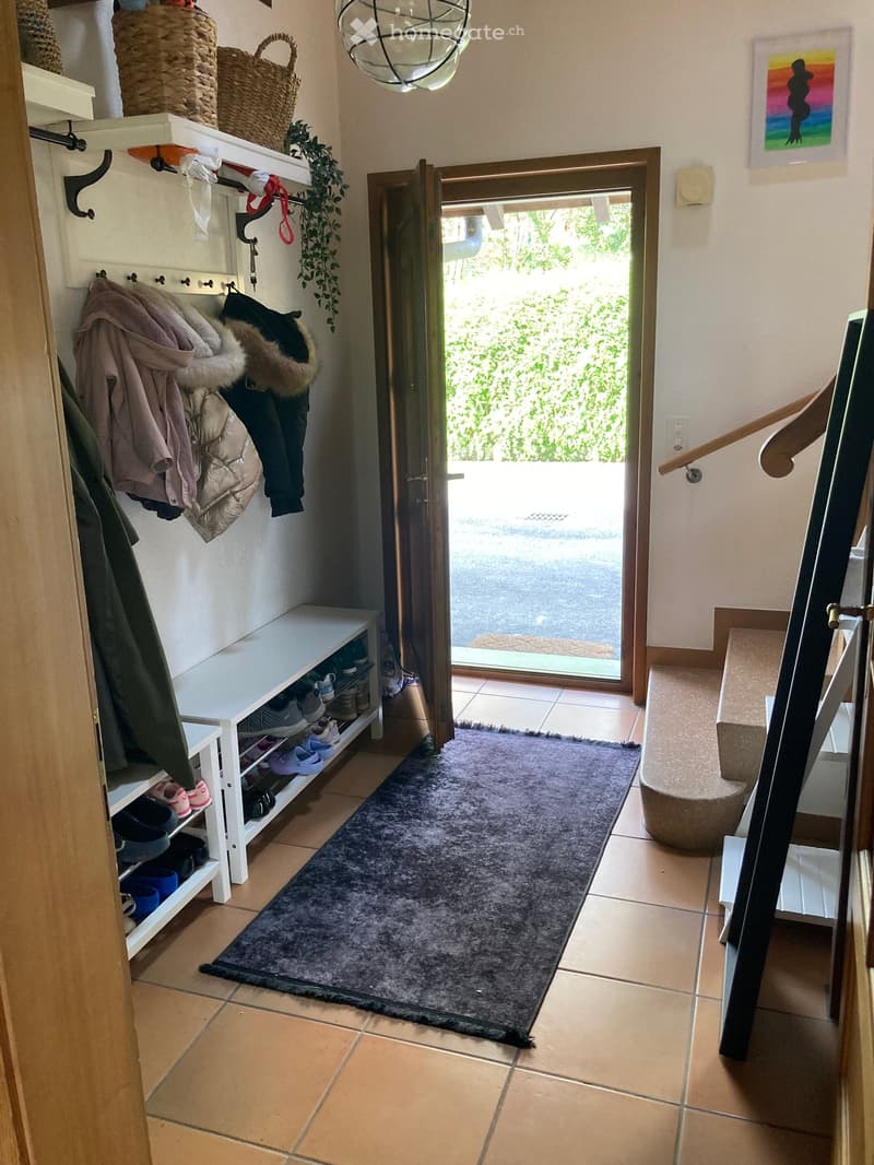 Entrance hall with coat rack, shoe rack, and a rug in front of the door