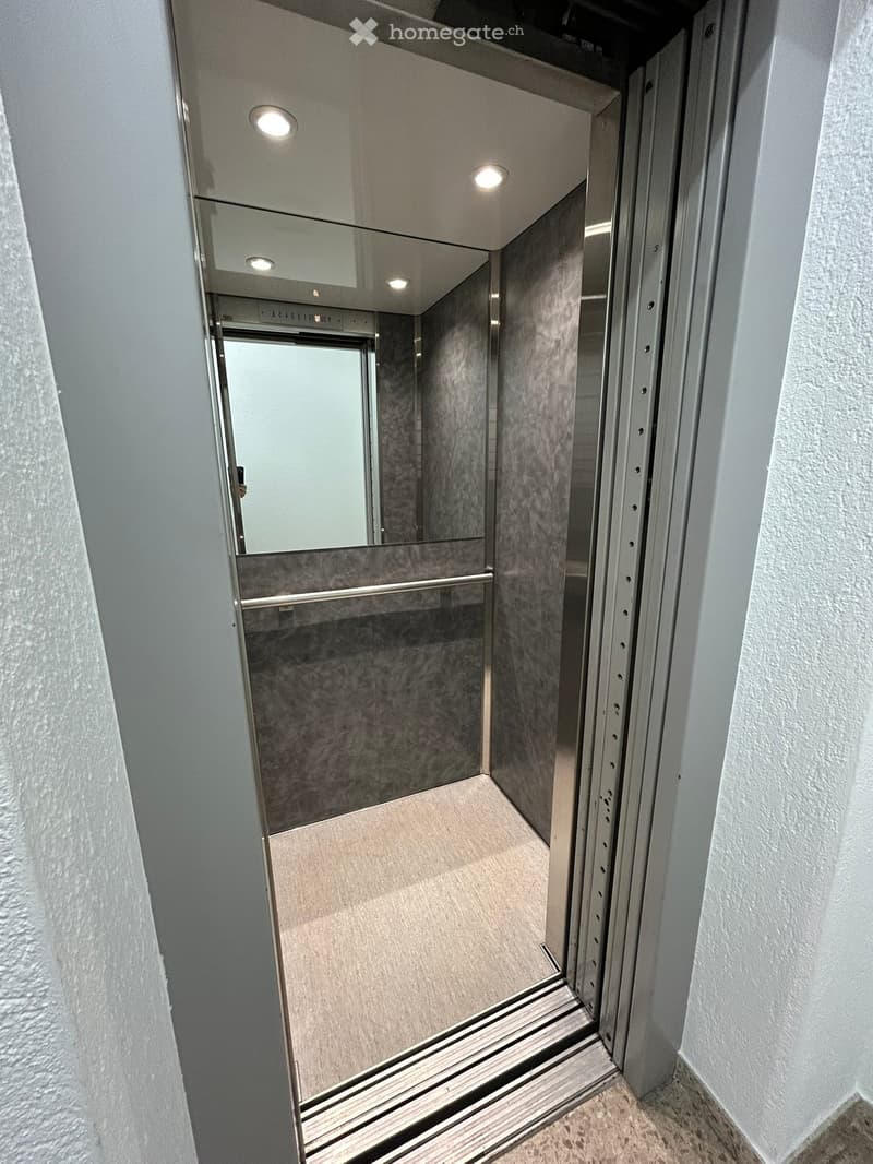 elevator with silver walls and gray floor