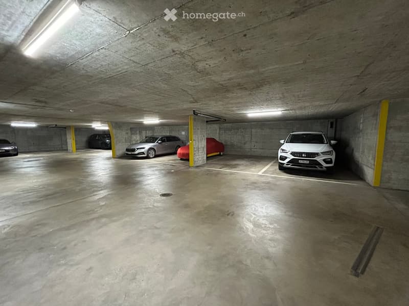 underground parking lot, concrete walls, yellow pillars, 4 cars parked