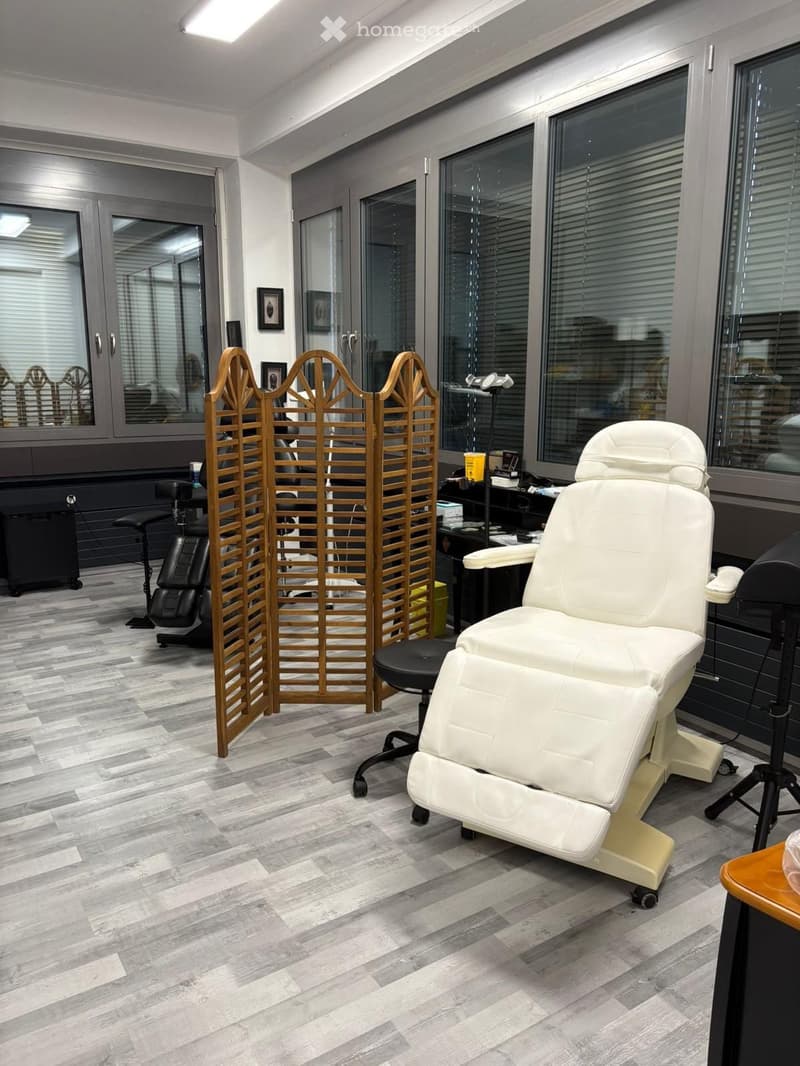 white leather reclining chair, wooden screen, black stool, glass windows, gray floor