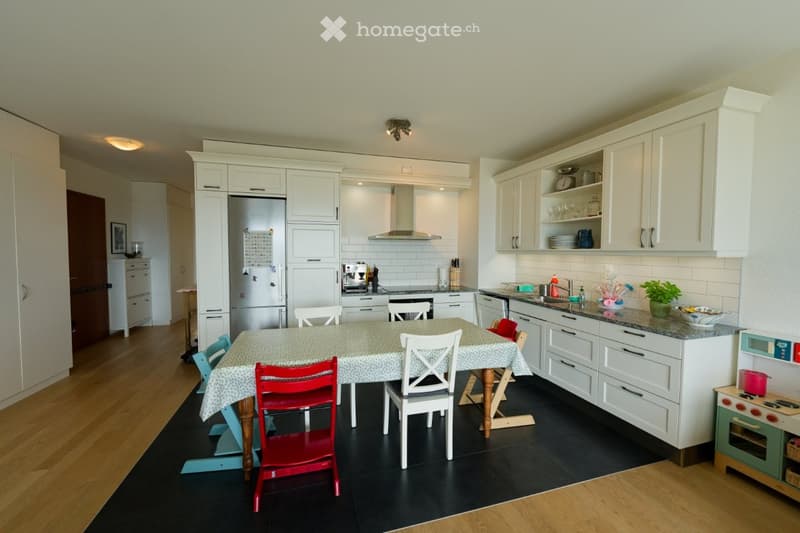 modern kitchen with white cabinets, wooden floor, dining table with chairs, refrigerator, stove, sink, and countertop with plants