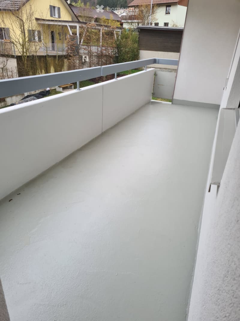 Balcony with white walls and floor, metal railing, empty