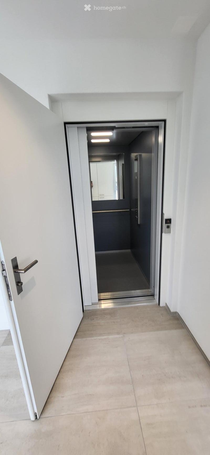 Open elevator door, white walls, tiled floor, mirror, control panel