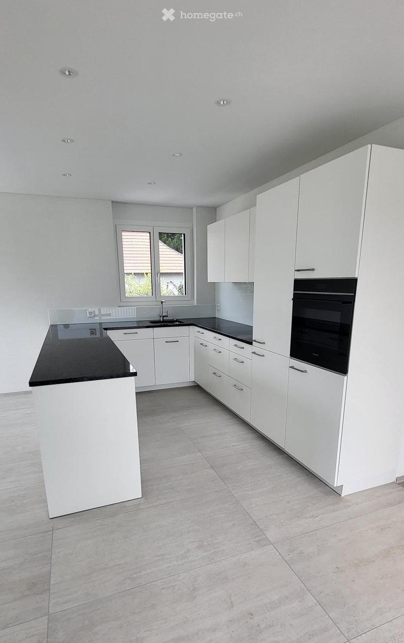 modern kitchen, white cabinets, black countertops, built-in oven, sink, faucet, tiled floor