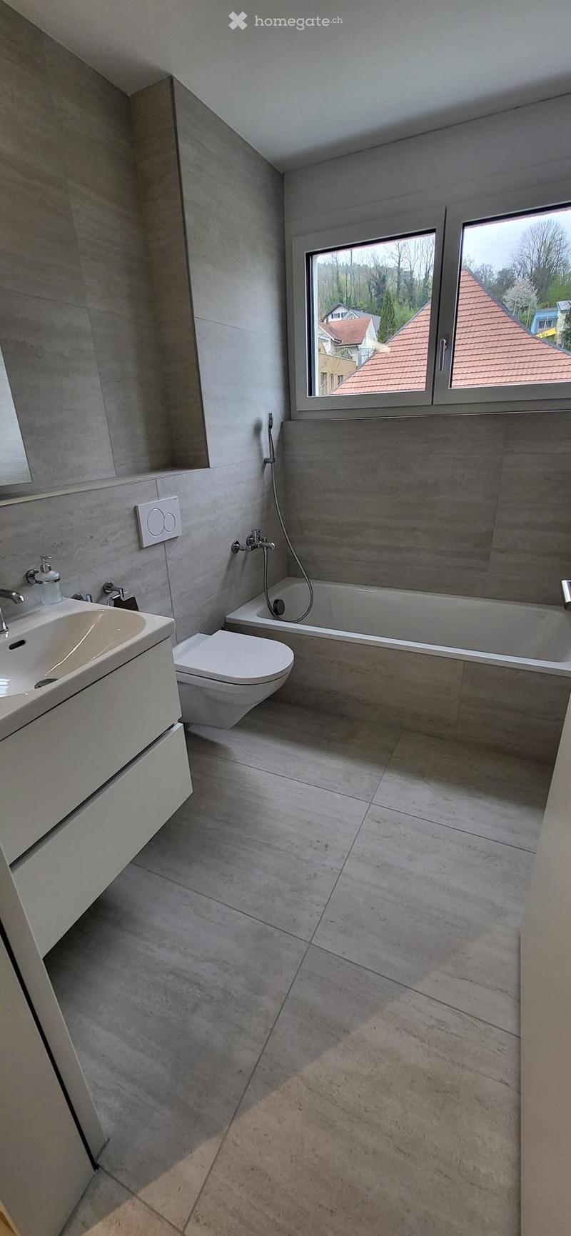modern bathroom with bathtub, toilet, sink, and shower head