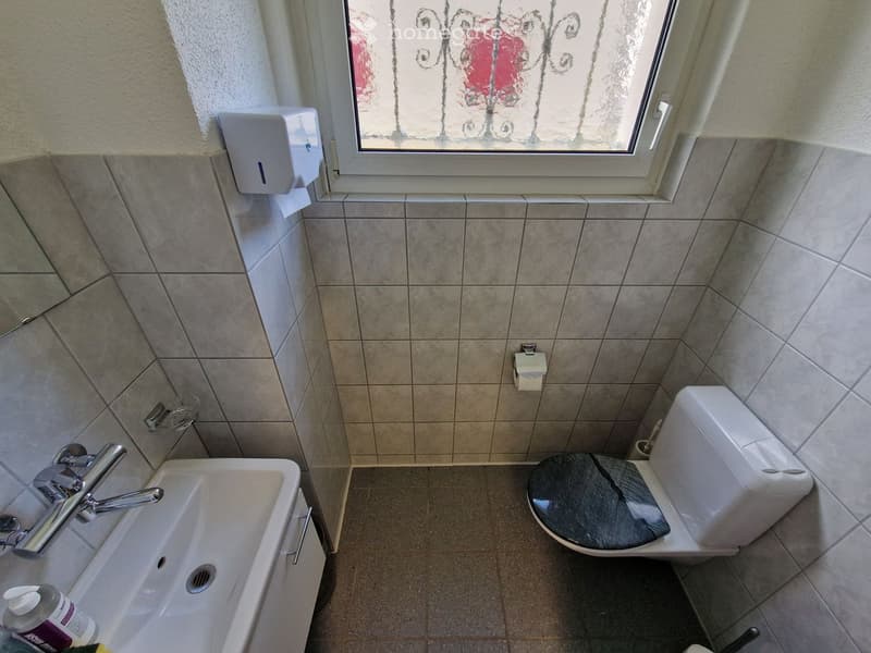 small bathroom with sink, toilet, and window