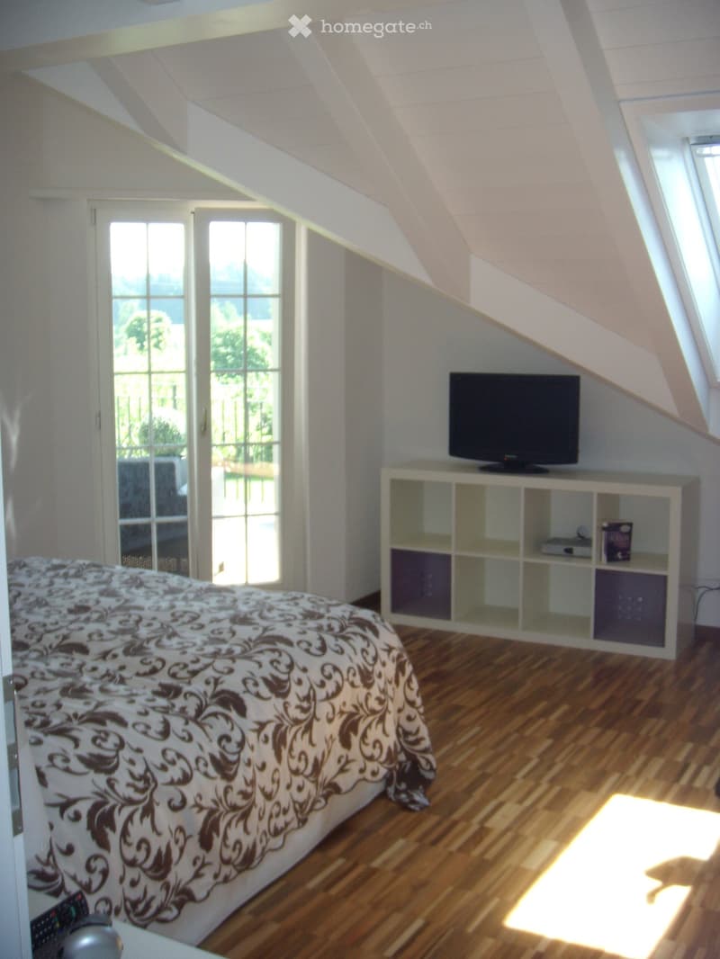 bedroom with bed, TV, shelves, balcony with view