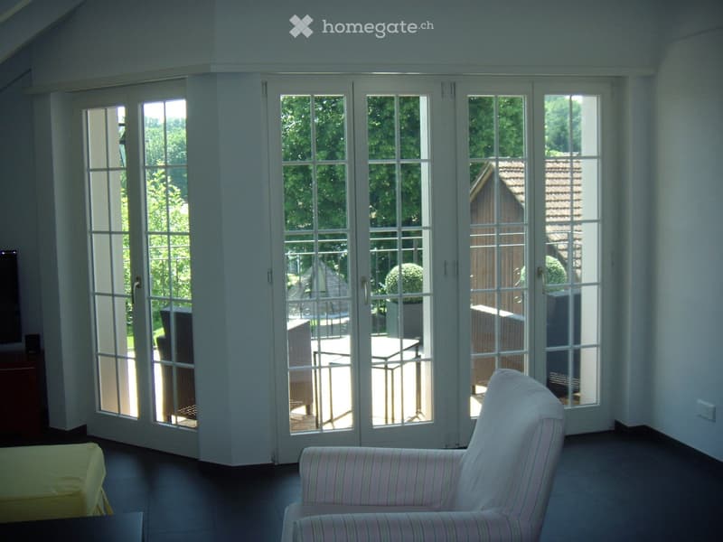 white walls, large glass doors, balcony, outdoor furniture, trees, house