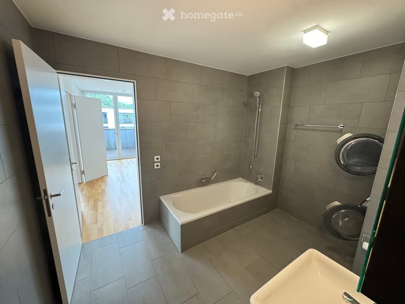 modern bathroom with bathtub, shower, sink, and washing machine