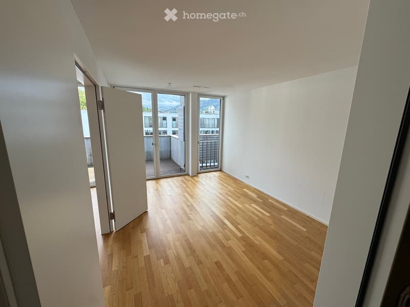 empty room, hardwood floors, white walls, sliding glass doors leading to balcony, no furniture