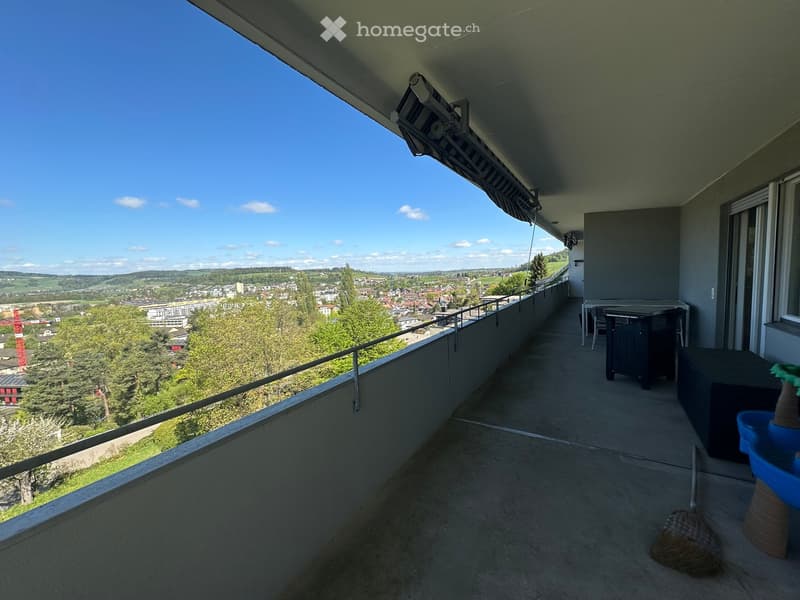 Balcony with railings, table, chairs, and a view of the city