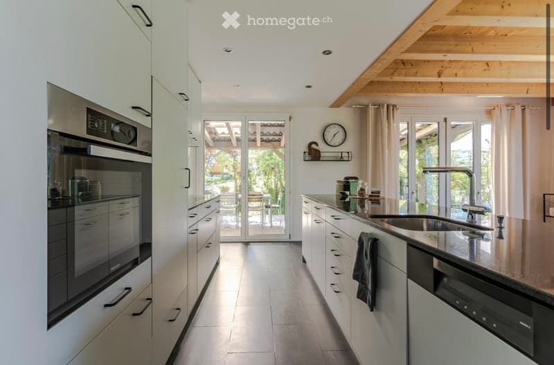 modern kitchen with white cabinets, granite countertops, stainless steel appliances, large windows, wooden ceiling
