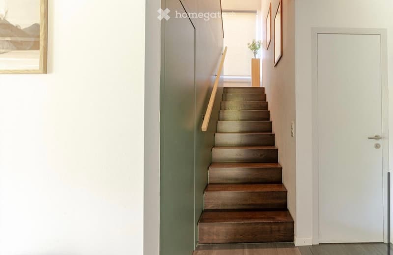 wooden staircase, white walls, wooden handrail, white door