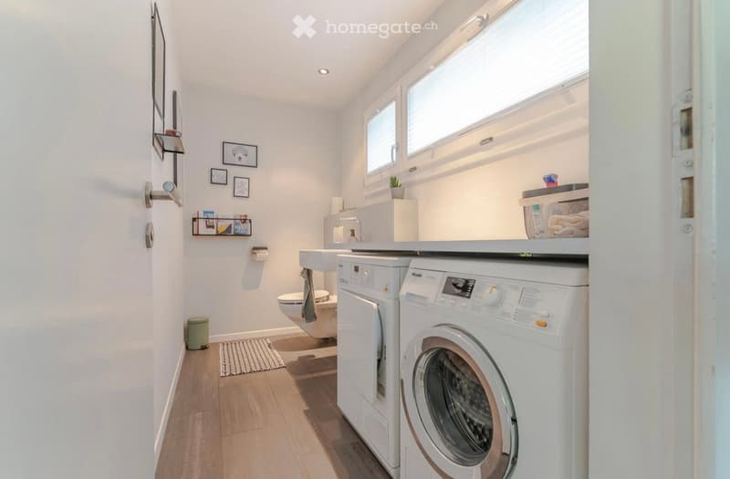 Laundry room with washing machine, dryer, sink, and toilet