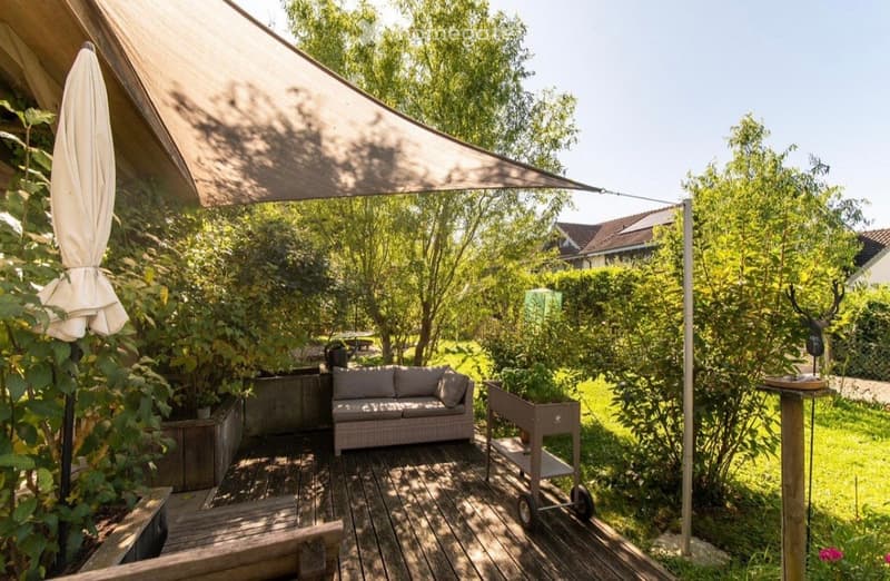 Wooden deck, outdoor sofa, canopy, plants, trees, grassy area