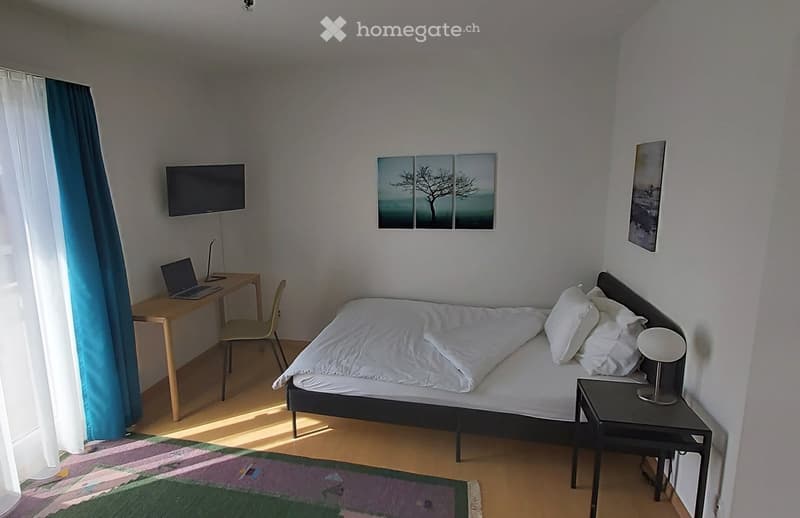 Bedroom: bed, desk, laptop, lamp, curtain, picture frames, rug, chair