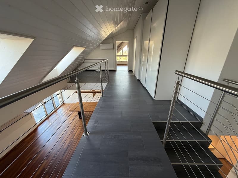 wooden floor, black tiles, metal railings, white walls, windows, wooden bench