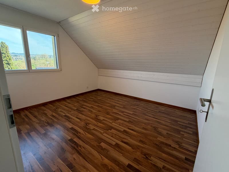 empty room, wooden floor, white walls, large window, slanted ceiling