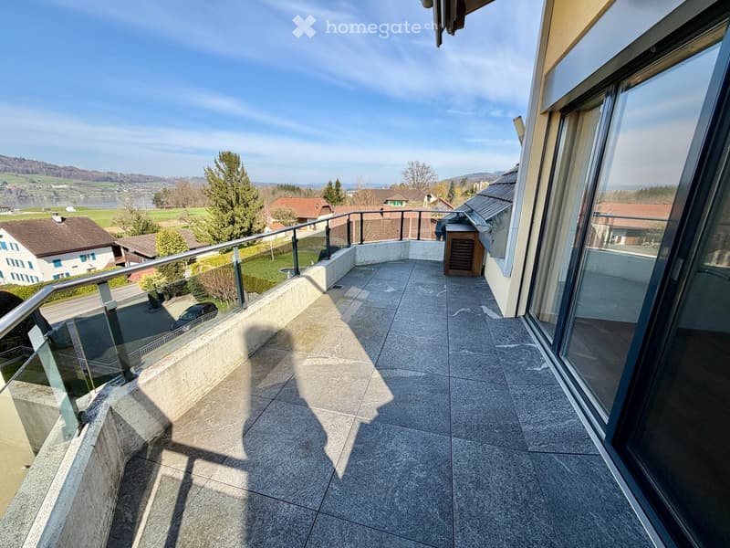 large balcony with glass railing, tiled floor, view of the landscape