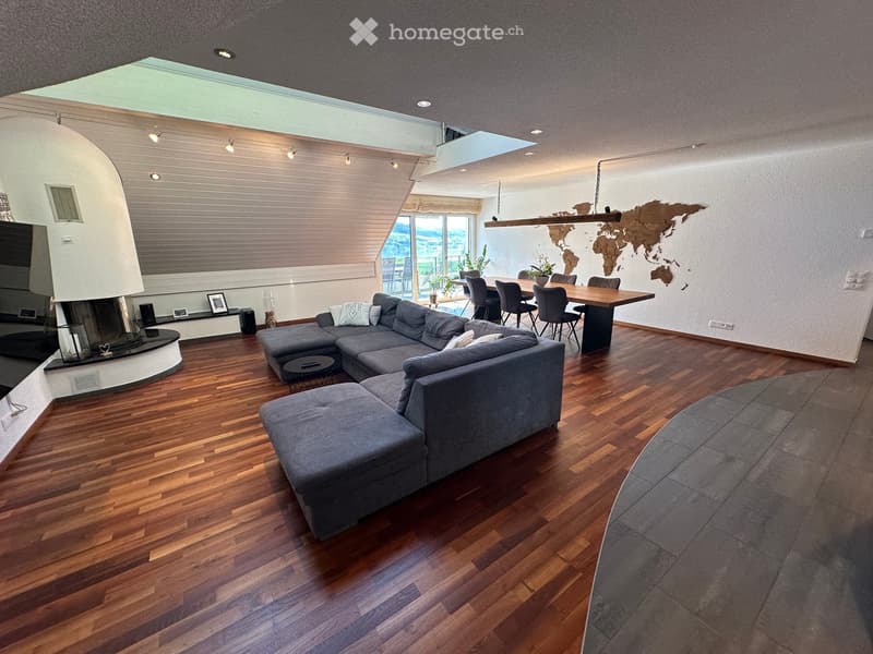 L-shaped sofa, hardwood floors, fireplace, dining table and chairs, potted plants, picture frames, ceiling lights, glass wall, world map