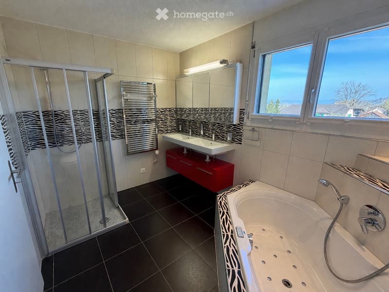 modern bathroom with black tiles, double sink, bathtub, shower, red cabinet, large windows