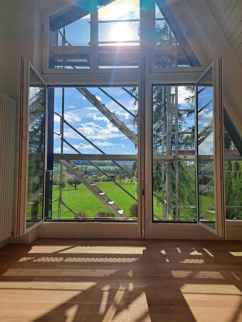 large windows, wooden floor, view of a green field