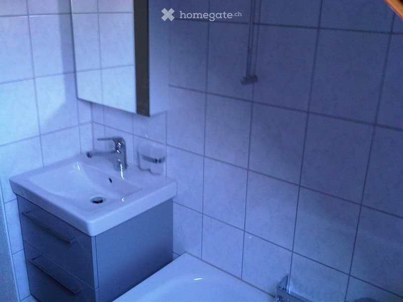 Bathroom with white tiles, sink, mirror, and bathtub