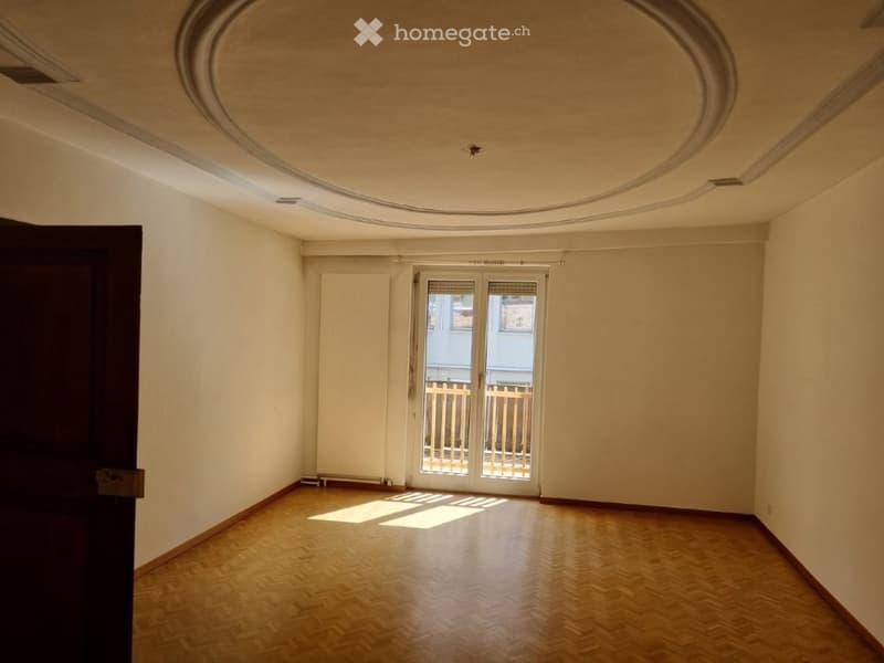 empty room, wooden floor, white walls, arched ceiling, sliding glass doors leading to balcony
