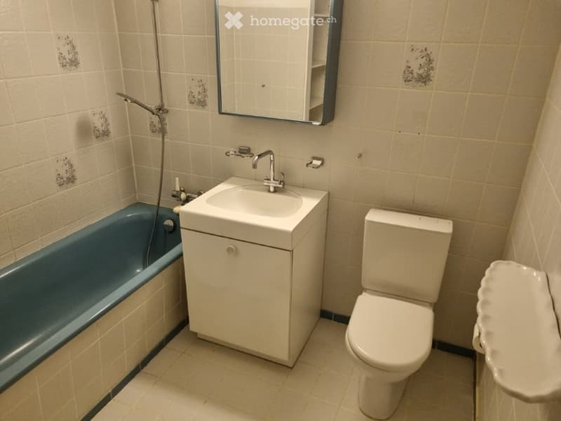 Bathroom with bathtub, sink, toilet, and mirror