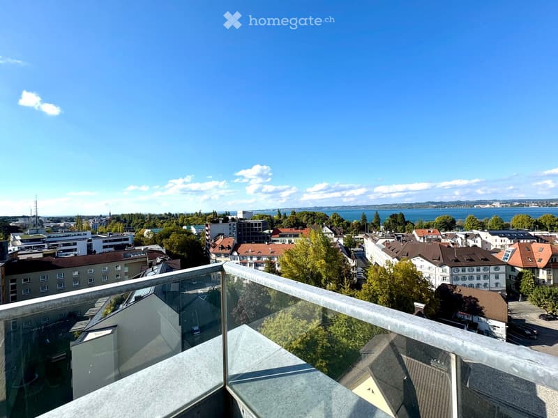 Balcony with glass railing, overlooking cityscape and water