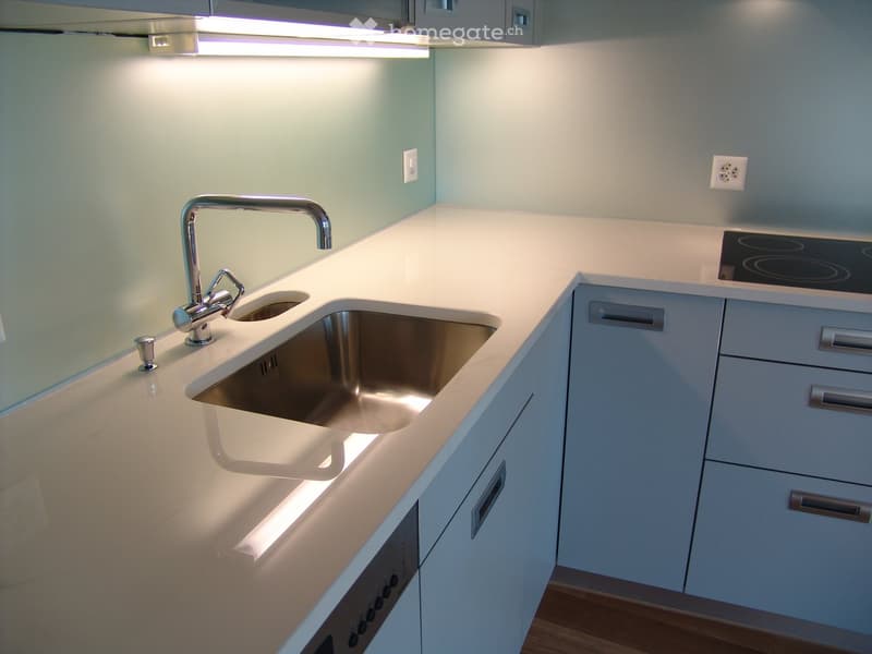 modern kitchen with white countertops, stainless steel sink, gas stove, dishwasher, white cabinets, under-cabinet lighting