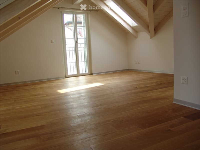 empty room, wooden floor, glass door, white walls, ceiling with wooden beams, power outlets