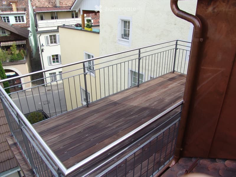 wooden floor, metal railing, overlooking street