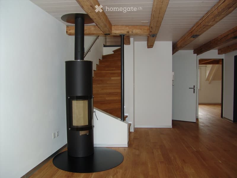 wooden floor, white walls, black fireplace, wooden beams, staircase
