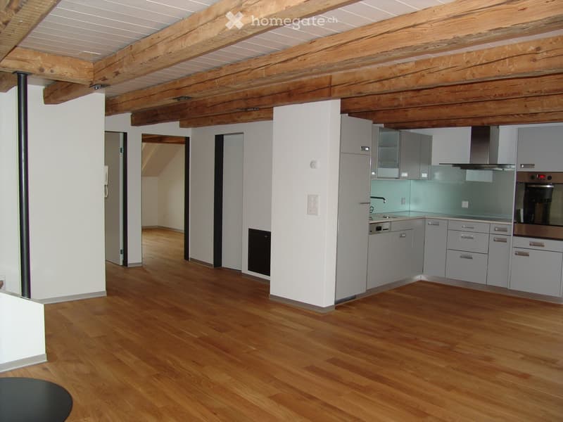 modern kitchen with wooden beams, white cabinets, stainless steel appliances, wooden floor