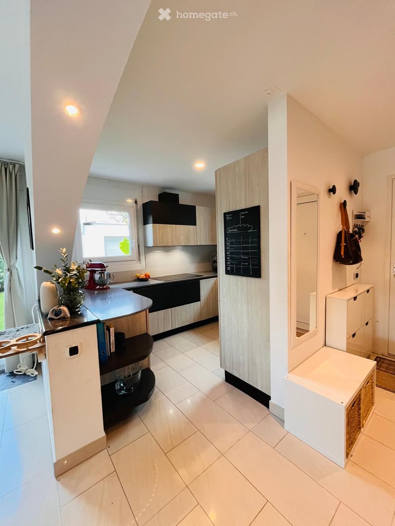modern kitchen with island, white cabinets, black countertops, white tiled floor, window, mirror, storage, blackboard, mixer, flower vase, bags, books, power outlet