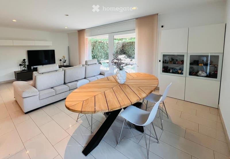 modern living room with white couch, wooden table, white chairs, TV, glass doors, white cabinets, tiled floor