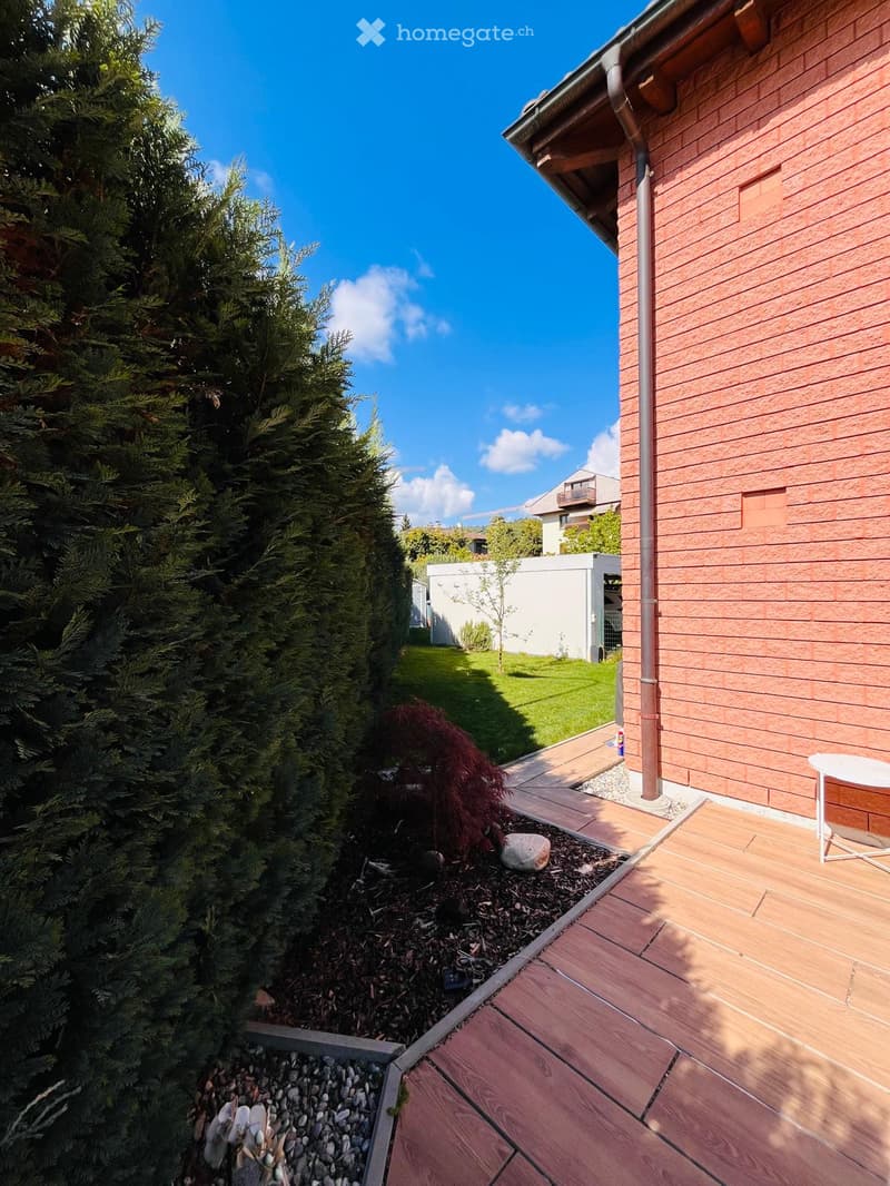 wooden deck, brick wall, hedge, small garden area, white fence, green grass