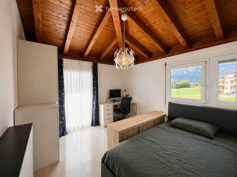 bedroom with bed, desk, chair, monitor, lamp, wooden ceiling, white walls, white tiled floor, windows with curtains, wardrobes