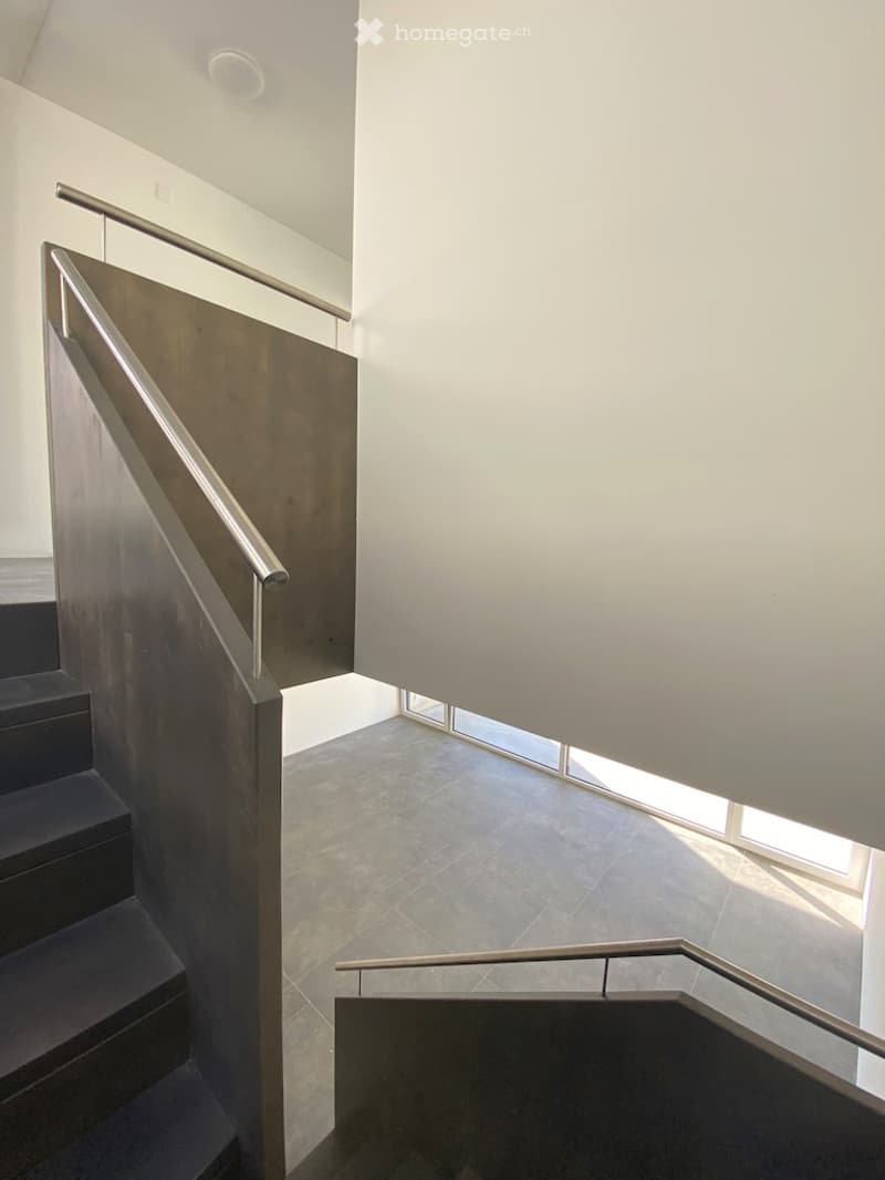 modern stairs with stainless steel handrail and landing, tiled floor, white walls