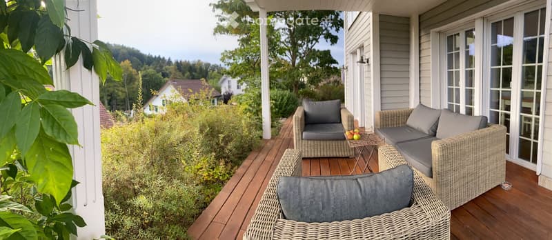 Wicker sofa chairs, small table, balcony deck, outdoor lighting, panoramic mountain view