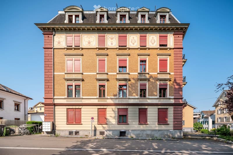 5 story building, brick facade, red shutters, multiple windows, located in a residential area